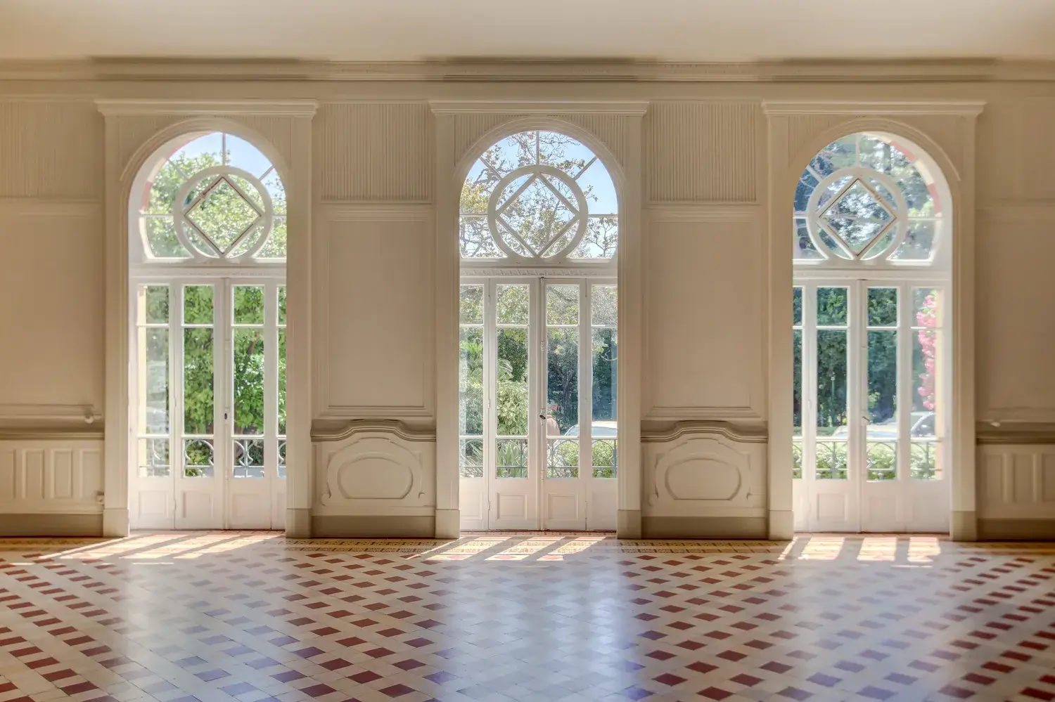 Salon d'un appartement Belle Époque à Cimiez : hauts plafonds, moulures et portes-fenêtres cintrées